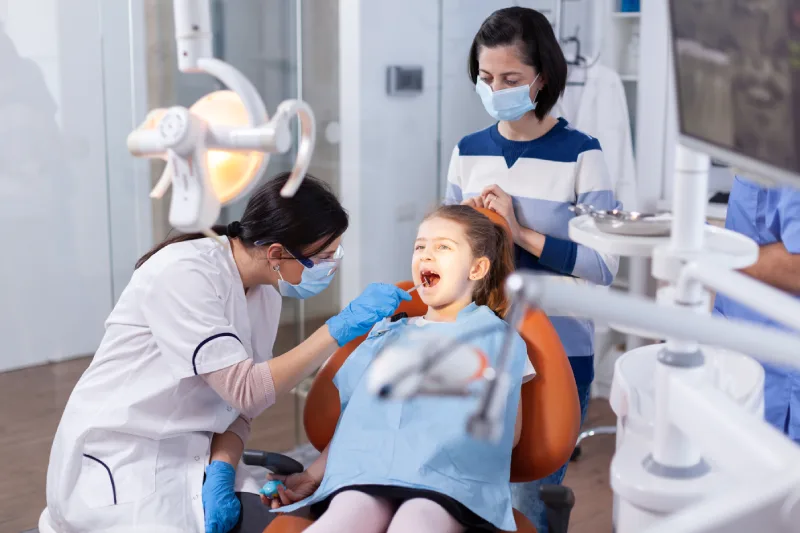 angled-mirror-used-by-dentist-doctor-little-girl-with-mouth-open-dental-office-dentistry-specialist-child-cavity-consultation-stomatology-office-using-modern-technology